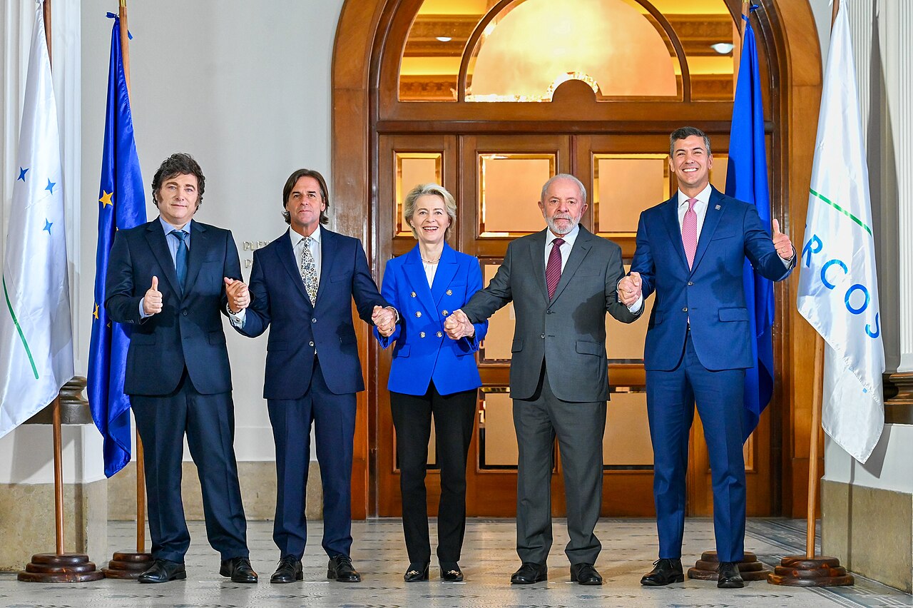Mercosur leaders and European Commission President Ursula von der Leyen holding hands in Montevideo after concluding EU–Mercosur negotiations, December 2024