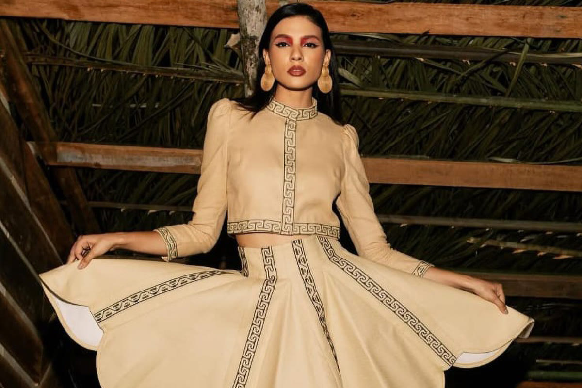 A model in a flared cream linen two-piece with Marajoara-inspired embroidered borders by Val Valadares